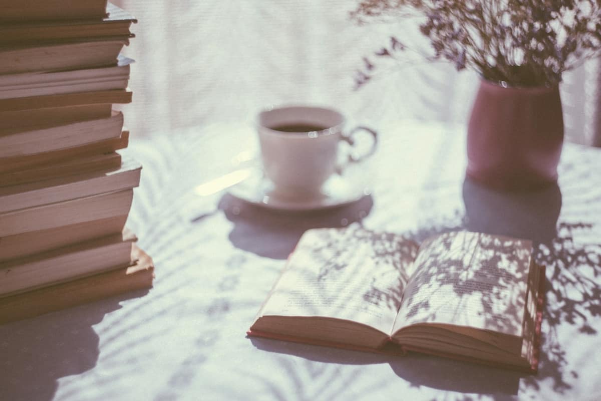 Old books and a coffee cup in soft morning light