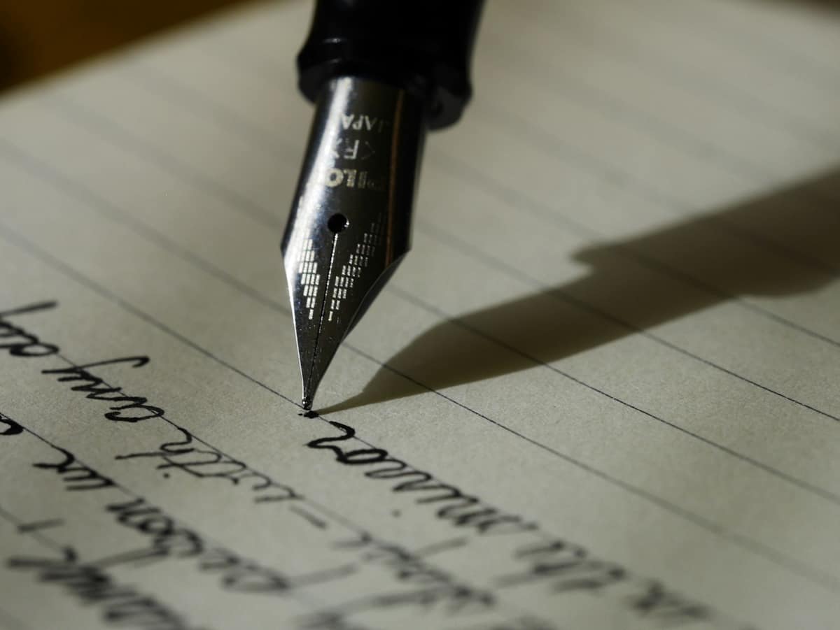 A fountain pen writing on lined paper